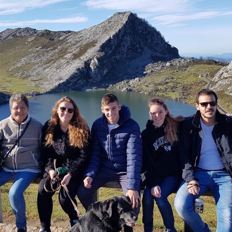 Group of five students with dog and a lake and mountain in the background